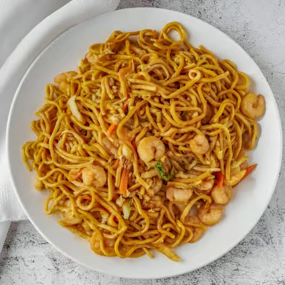 Red Wok's shrimp lo mein with noodles, shrimp, and vegetables on a white plate.
