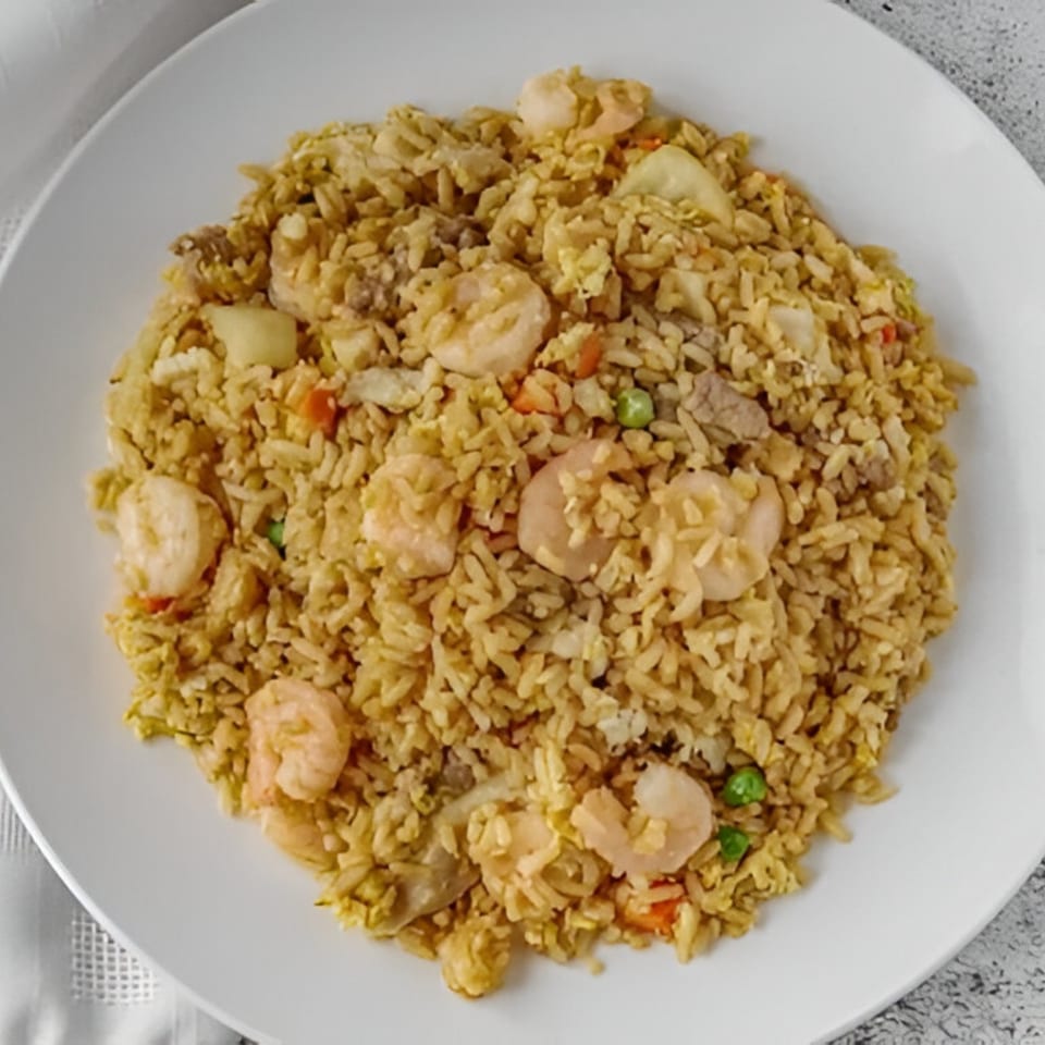 Red Wok's shrimp fried rice with vegetables and meat, served on a white plate.