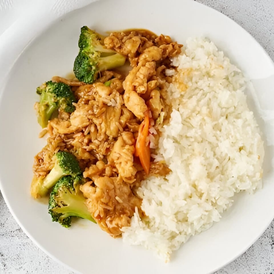 Red Wok's chicken and broccoli stir-fry with white rice on a white plate.
